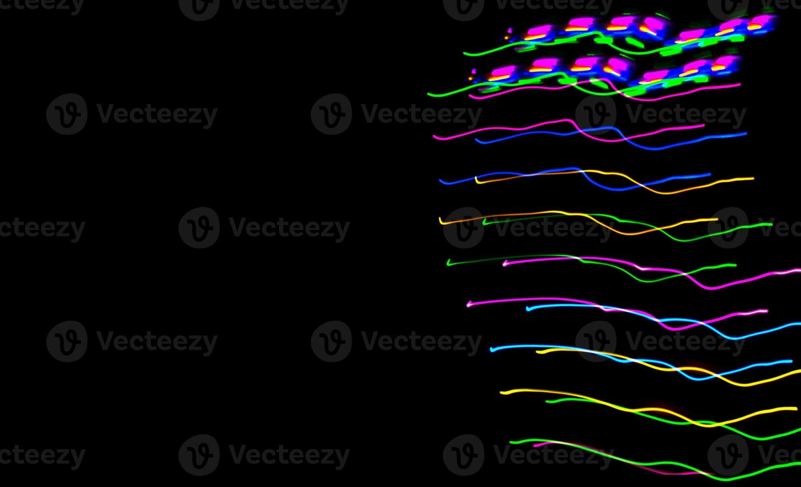 Multi color light painting photography, swirl and curve of blue, green and red light against a black background. photo