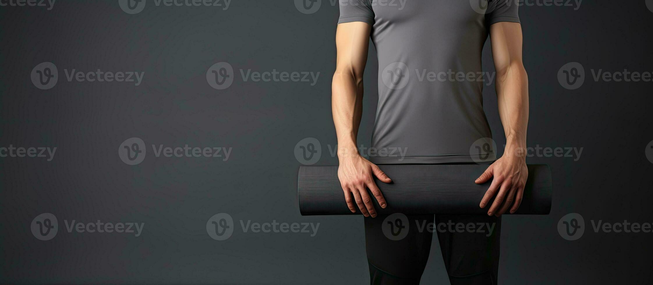 Slim fit model in sportswear holding yoga mat standing isolated on gray background after pilates or fitness training photo