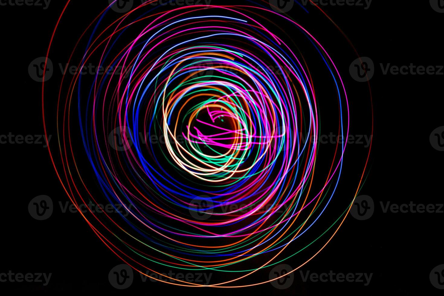 Multi color light painting photography, swirl and curve of blue, green and red light against a black background. photo