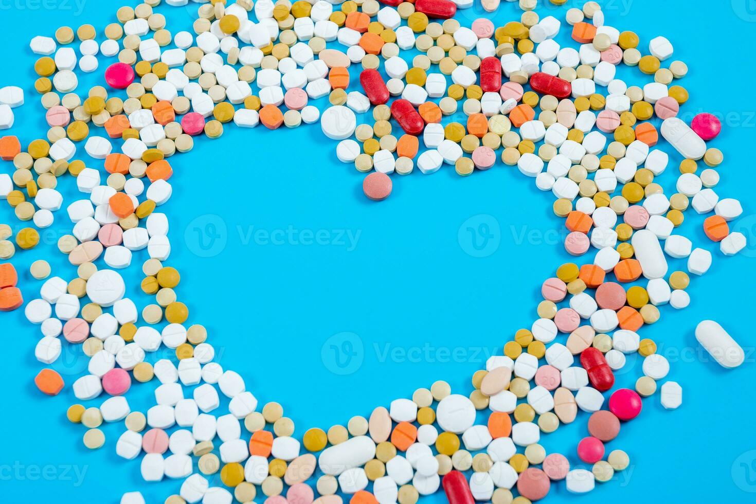 Many pills in the form of a heart Multicolored on a blue background photo