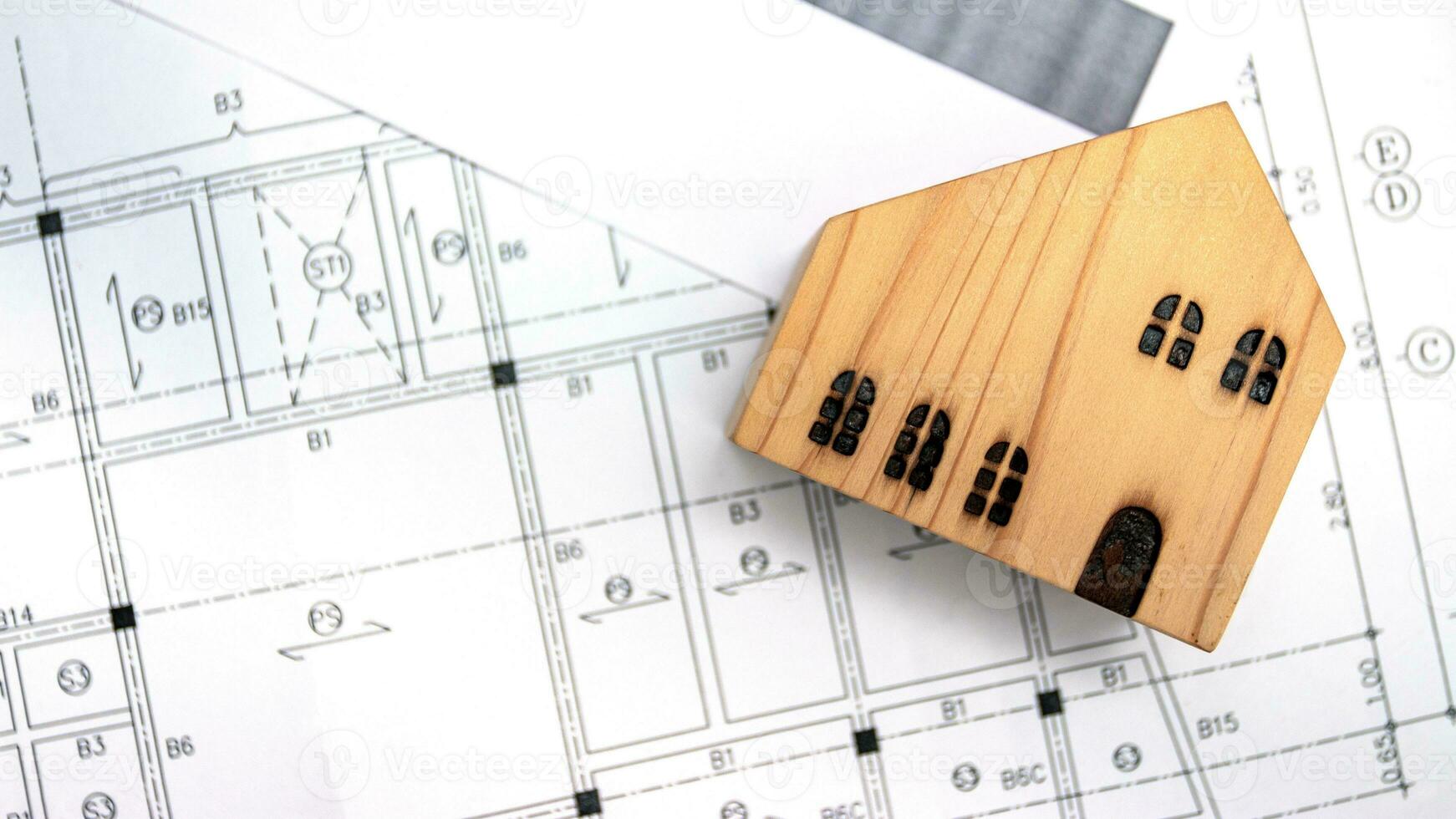 real estate and property, architecture, building, construction concept - Tiny house model on an architect's desk photo