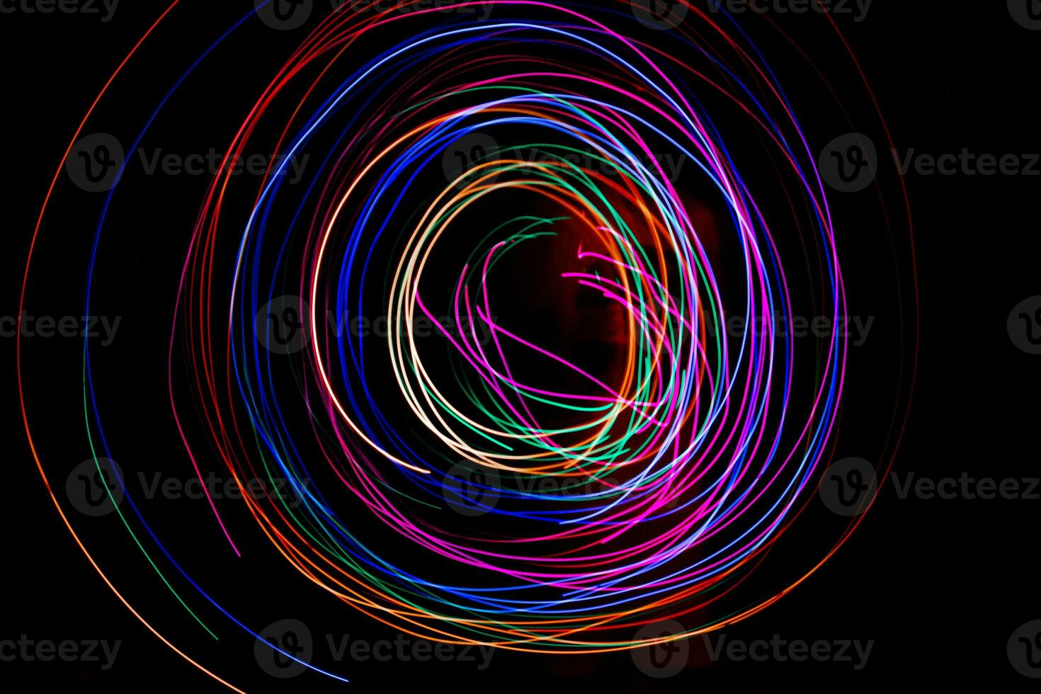 Multi color light painting photography, swirl and curve of blue, green and red light against a black background. photo