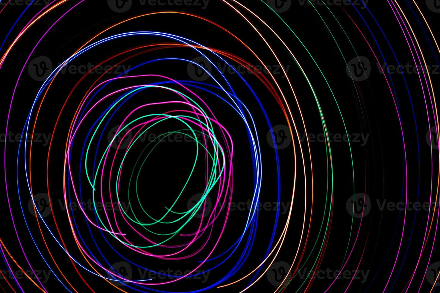 Multi color light painting photography, swirl and curve of blue, green and red light against a black background. photo