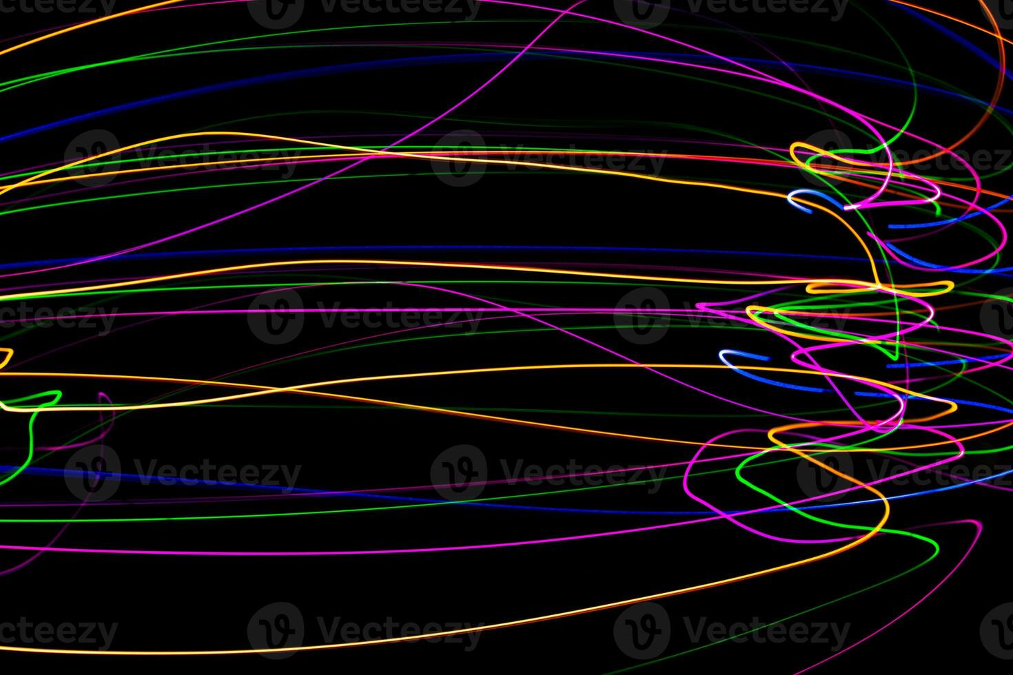 Multi color light painting photography, swirl and curve of blue, green and red light against a black background. photo