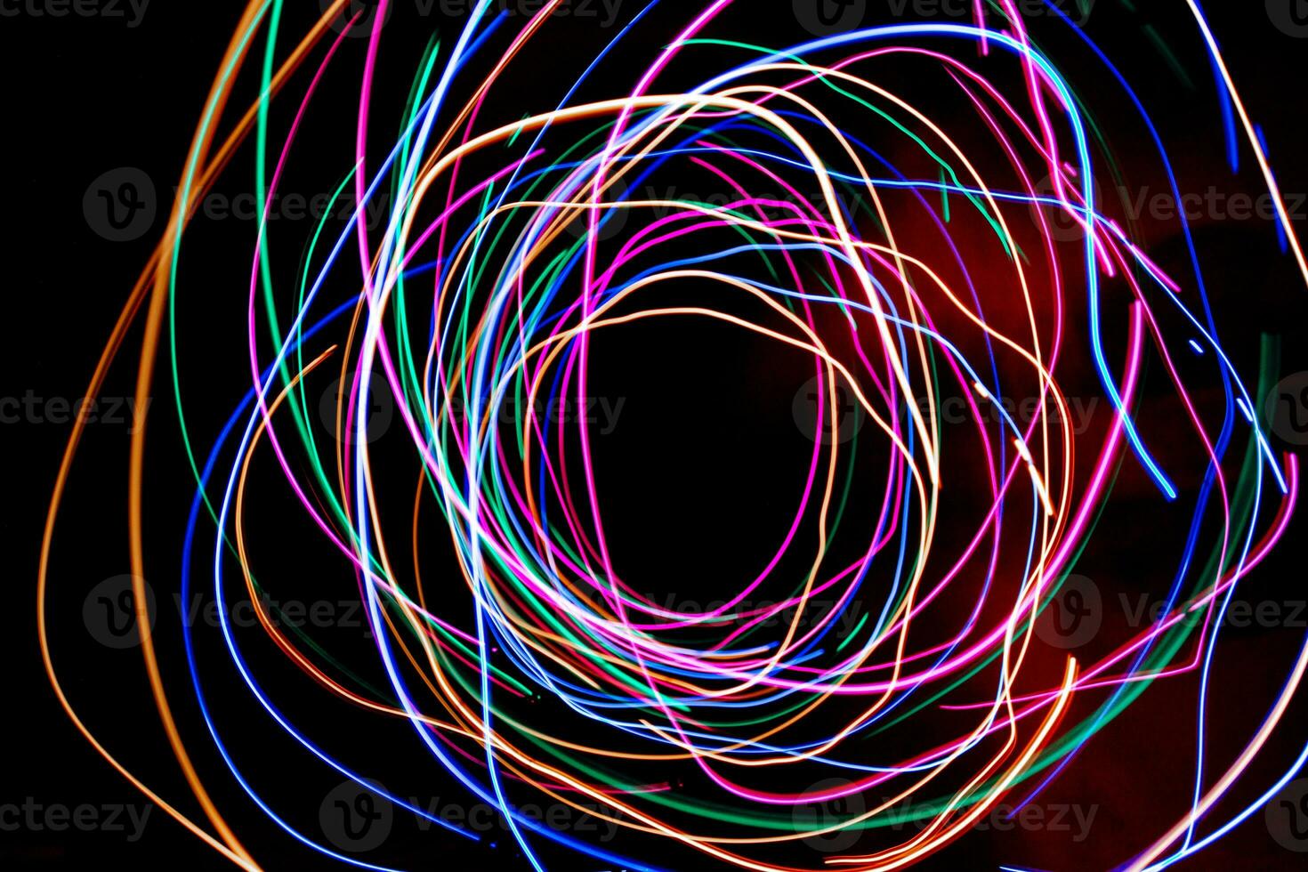 Multi color light painting photography, swirl and curve of blue, green and red light against a black background. photo