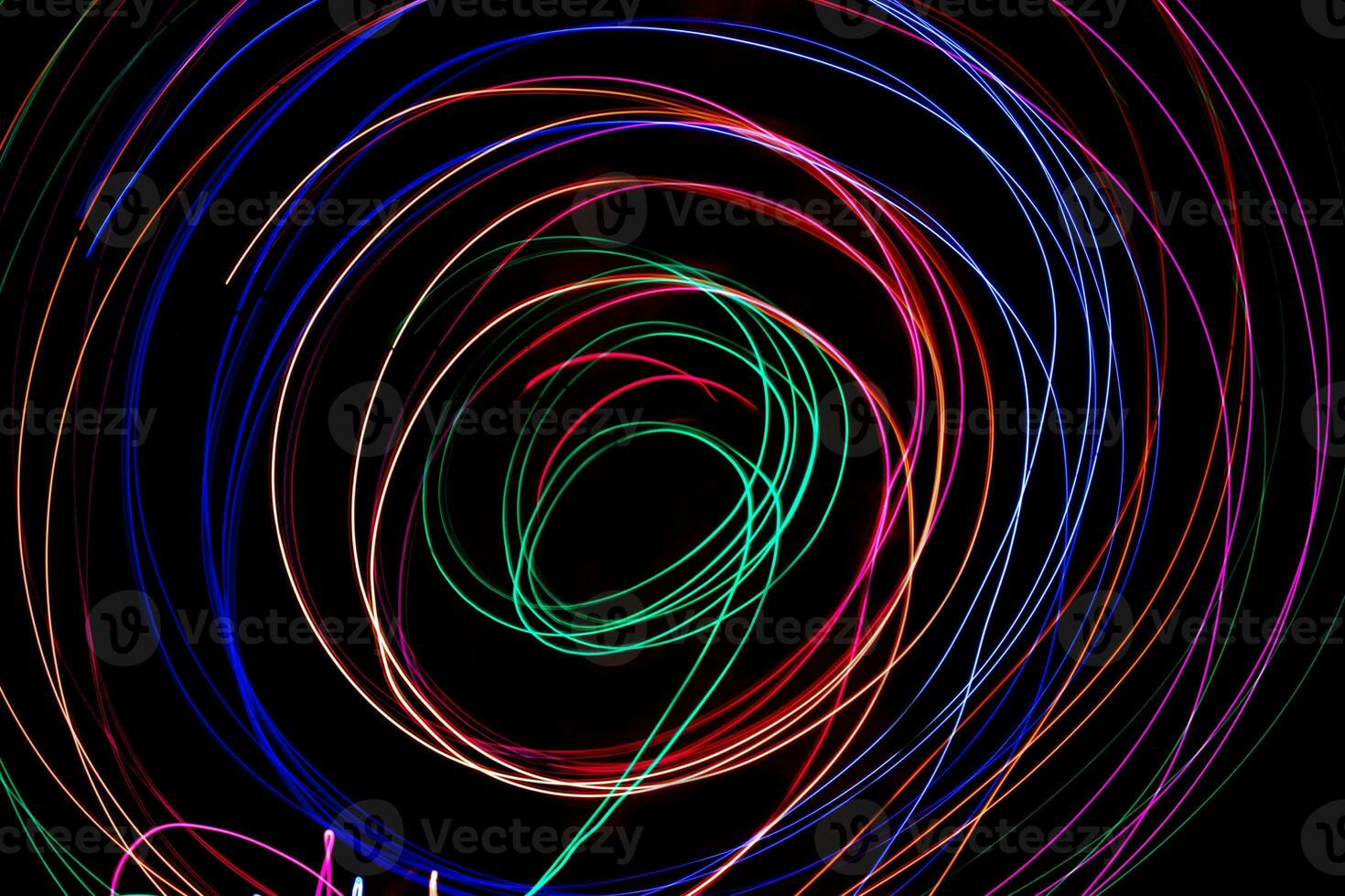 Multi color light painting photography, swirl and curve of blue, green and red light against a black background. photo