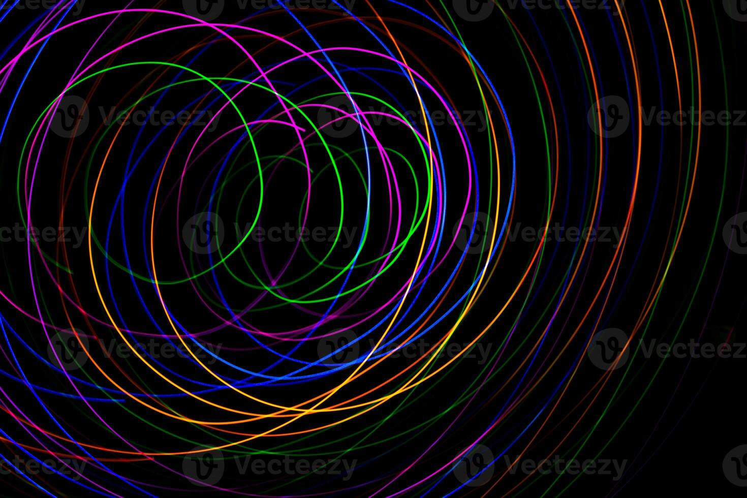 Multi color light painting photography, swirl and curve of blue, green and red light against a black background. photo