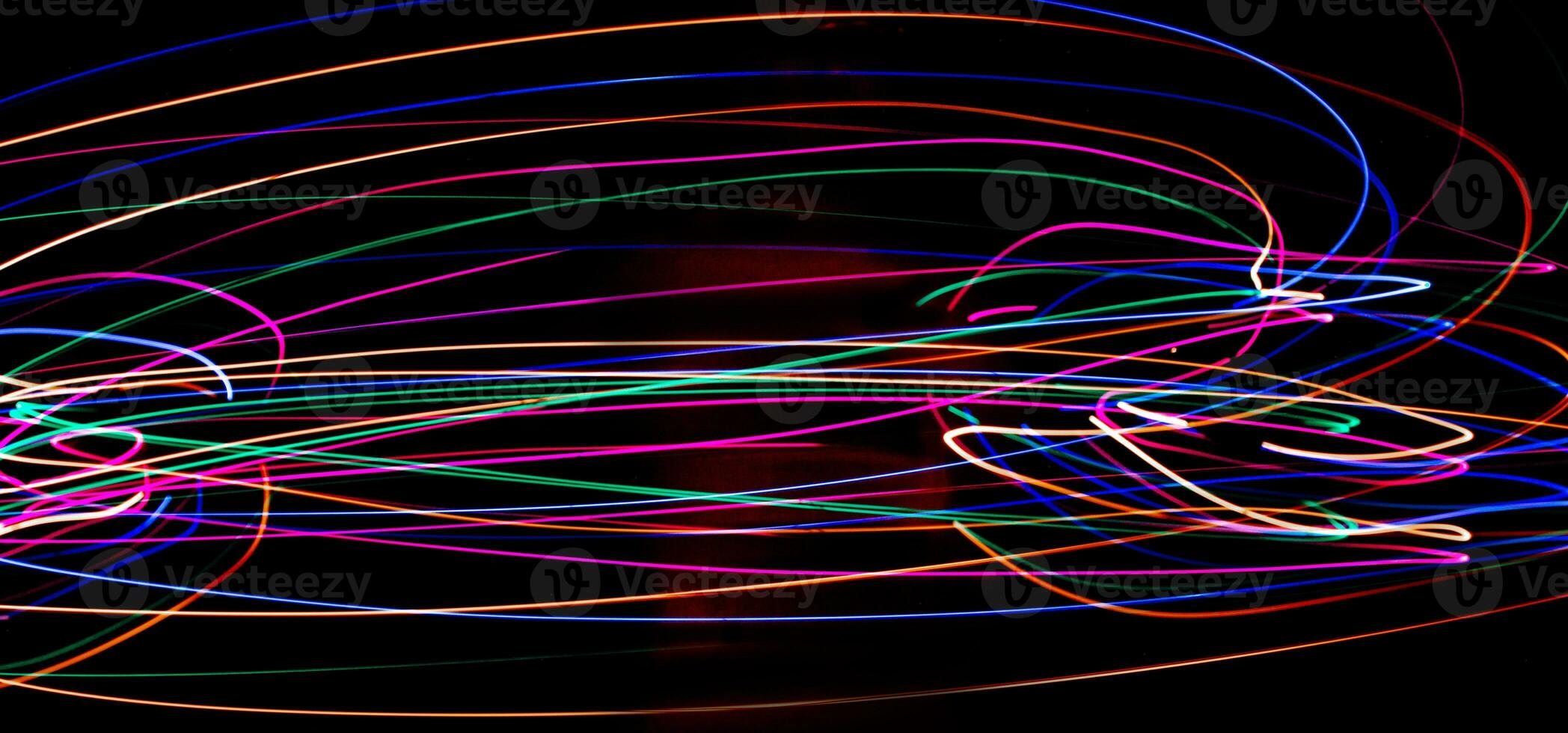 Multi color light painting photography, swirl and curve of blue, green and red light against a black background. photo