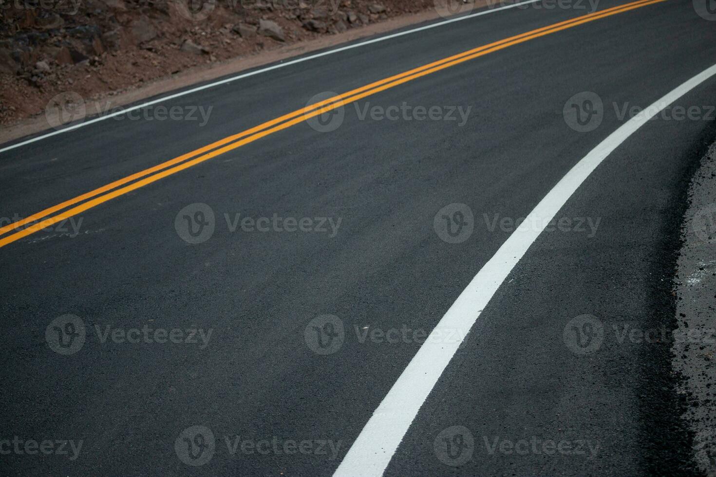 el asfalto la carretera tiene amarillo y blanco tráfico líneas cruce el montañas. foto