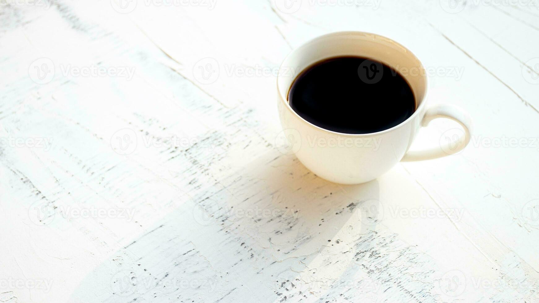 Coffee cup on the wooden table in the morning photo