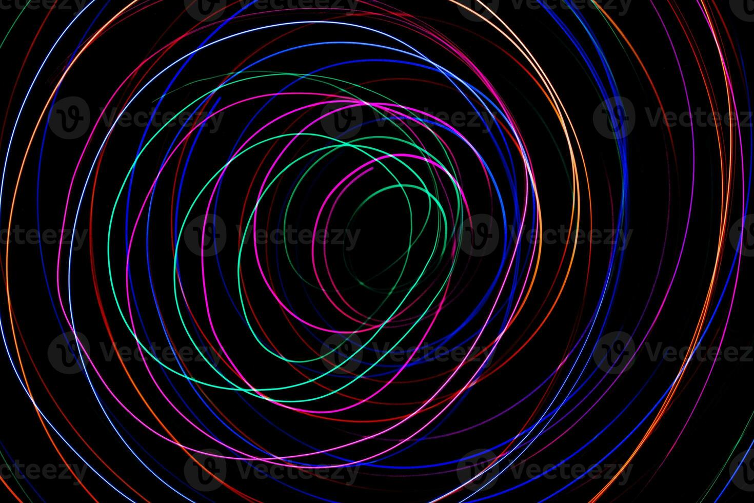Multi color light painting photography, swirl and curve of blue, green and red light against a black background. photo