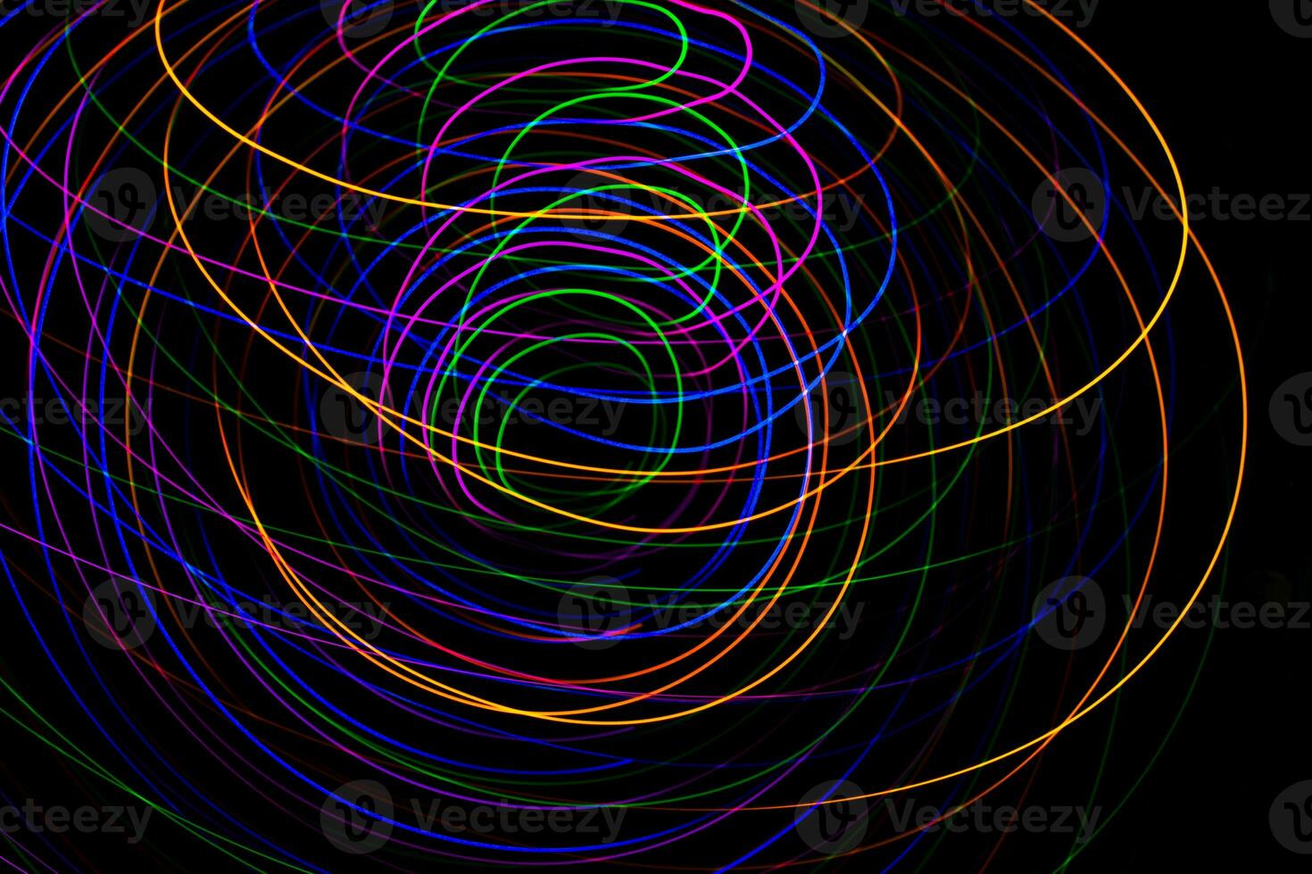 Multi color light painting photography, swirl and curve of blue, green and red light against a black background. photo