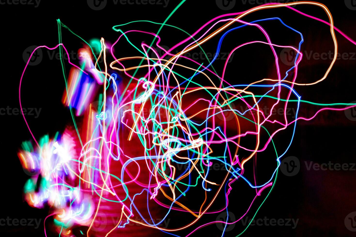 Multi color light painting photography, swirl and curve of blue, green and red light against a black background. photo