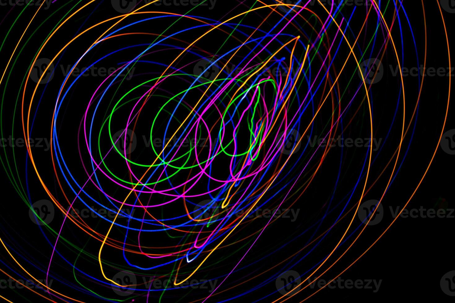 Multi color light painting photography, swirl and curve of blue, green and red light against a black background. photo