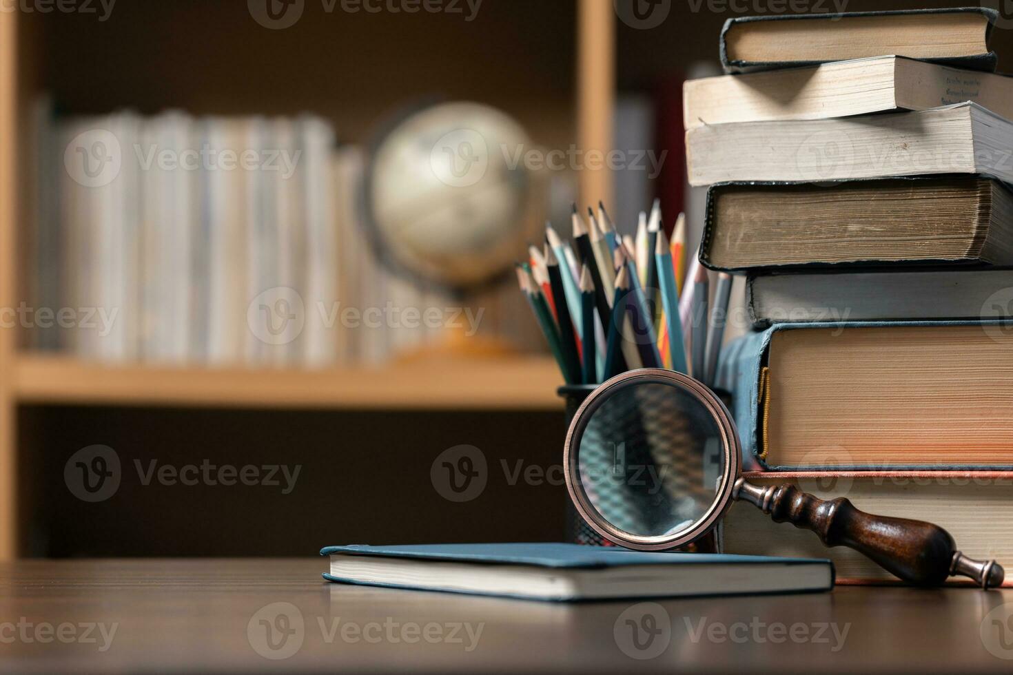 Education learning concept. Book in library with old open textbook, stack piles of literature text archive on reading desk, aisle of bookshelves in school study class room background for academic photo