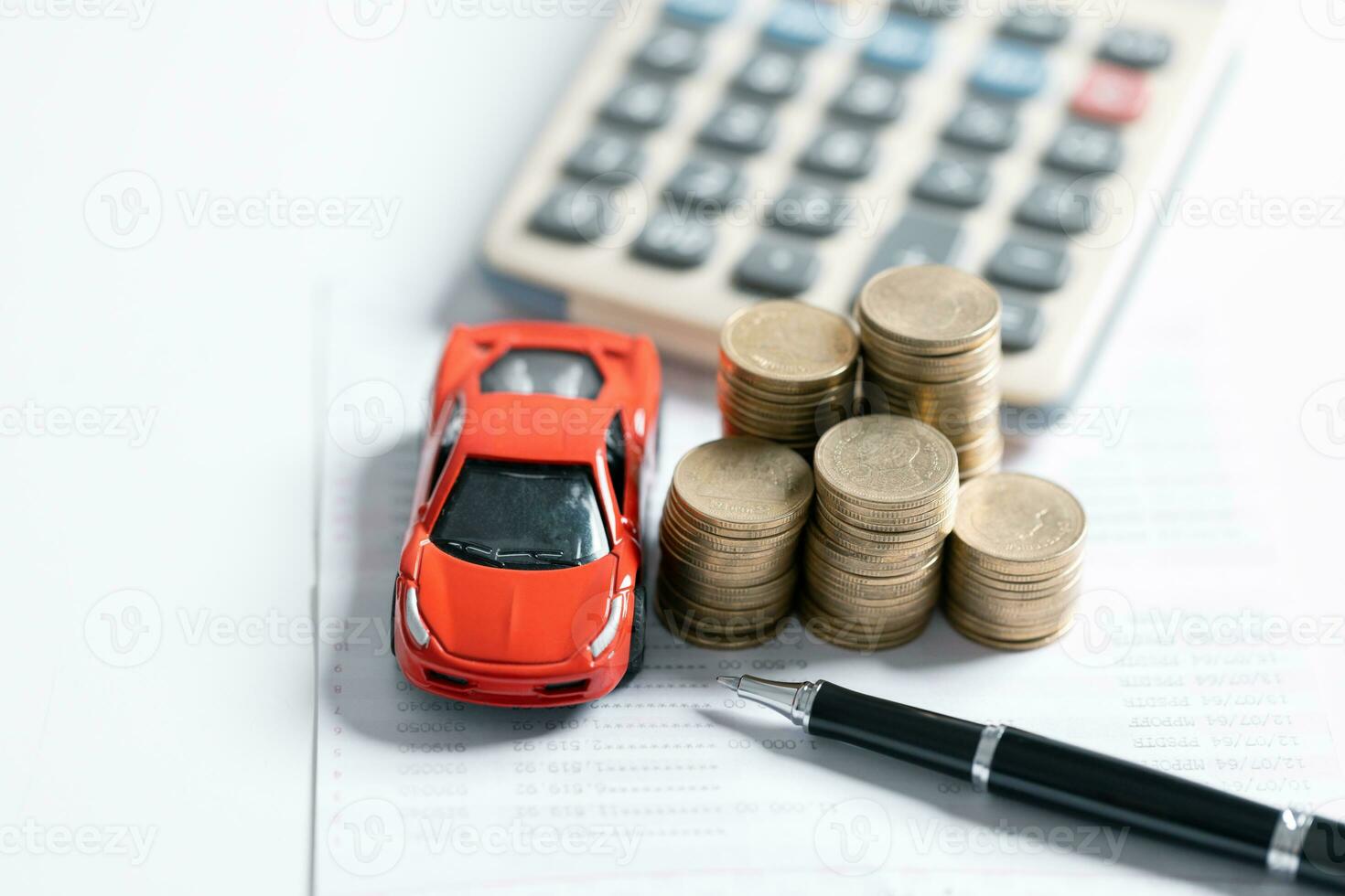 Top view of miniature car model, calculator and pen on office desk table. Business, finance, saving money, banking or car loan concept. Car, coins and calculator with copy space. photo