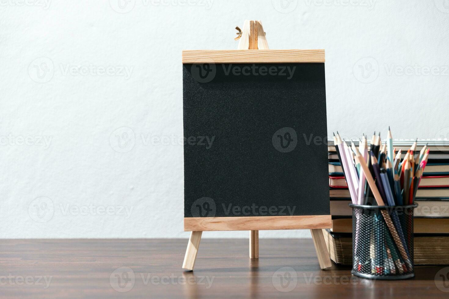 Back to school background with books on wooden table over chalkboard photo