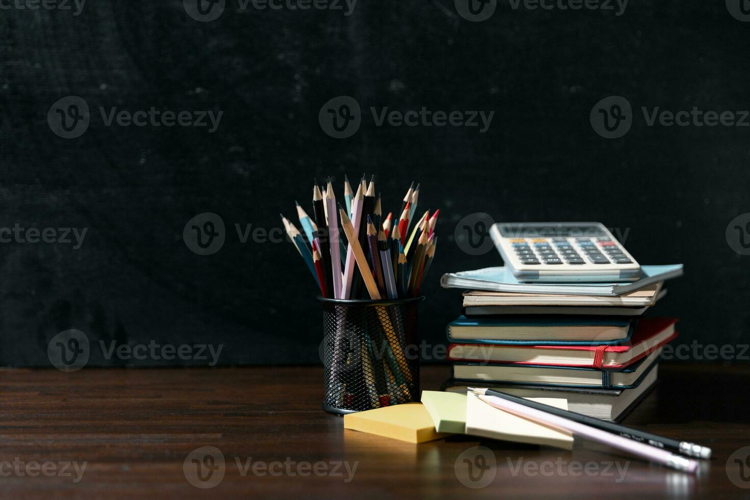 Back to school background with books on wooden table over chalkboard photo