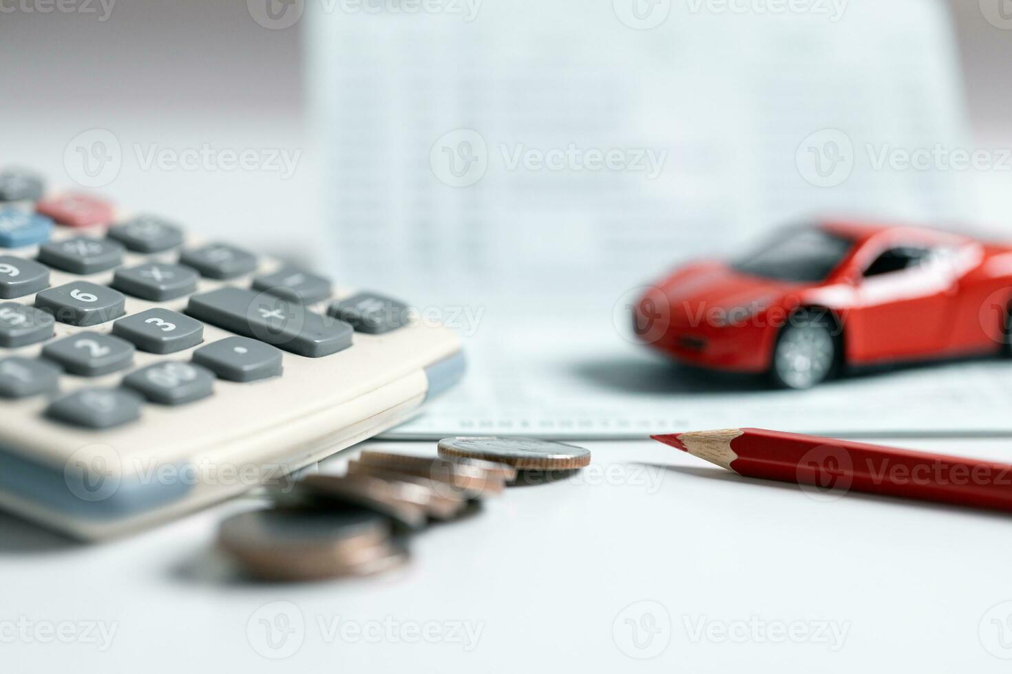 Top view of miniature car model, calculator and pen on office desk table. Business, finance, saving money, banking or car loan concept. Car, coins and calculator with copy space. photo