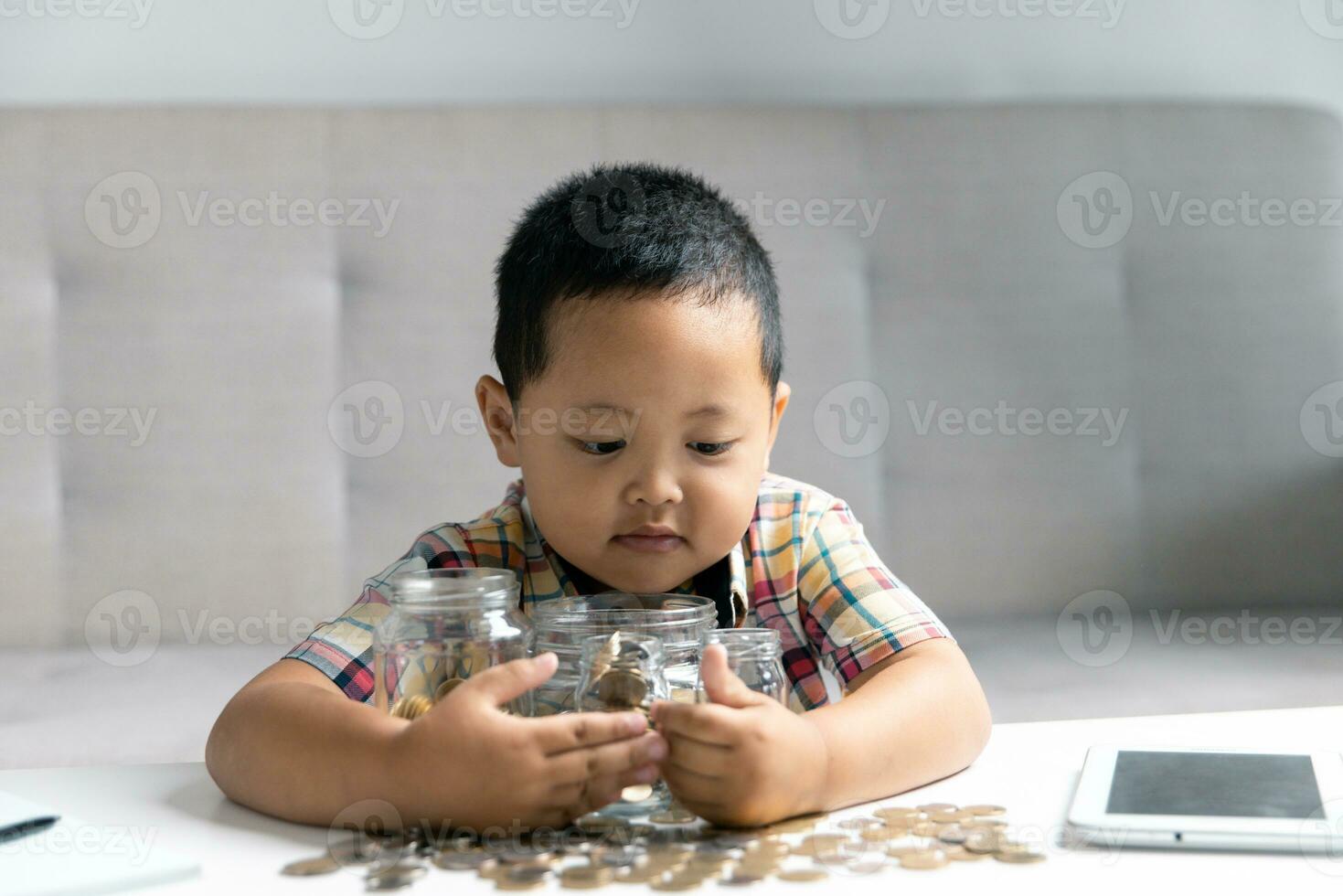 Preschooler child learning to calculate personal budget, manage finance, playing investment, accounting. Focused school kid saving money for purchase, putting cash in pink piggy bank at home. photo