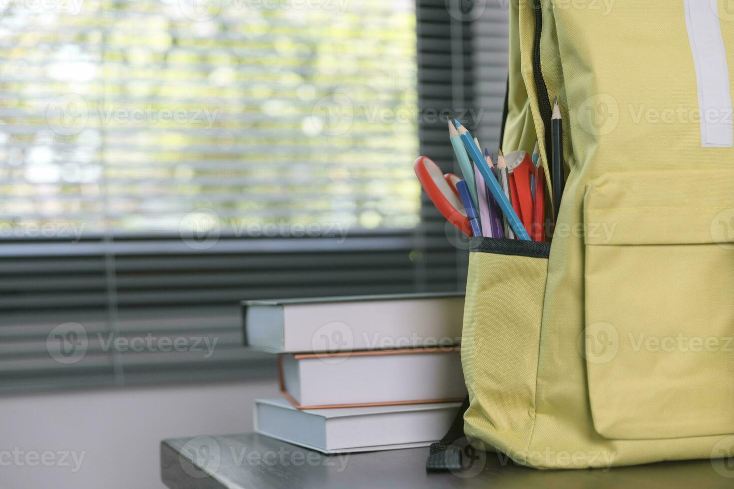 School supplies on wooden table in warm interior, school books on table, education concept. photo