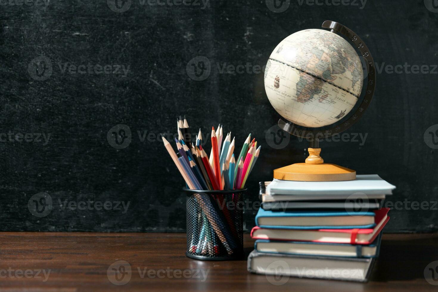 Back to school background with books on wooden table over chalkboard photo