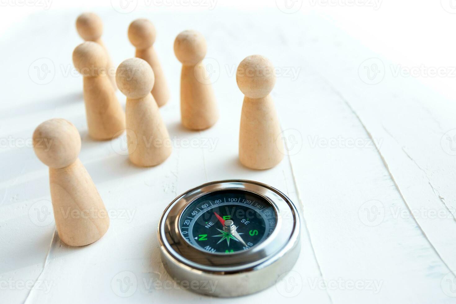 Compass and wooden puppet on a white wooden background, Concept of employee selection photo