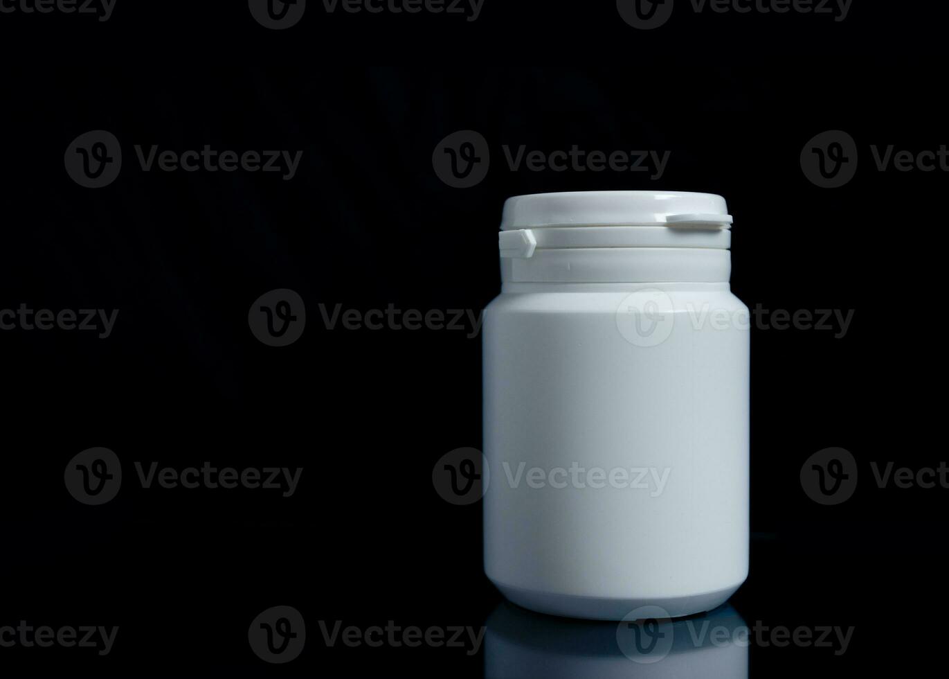 White medicine bottle on black background, medical concept. photo