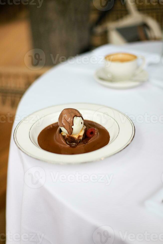 Brownie with ice cream and chocolate sauce. Brownie with raspberries. vertical photo