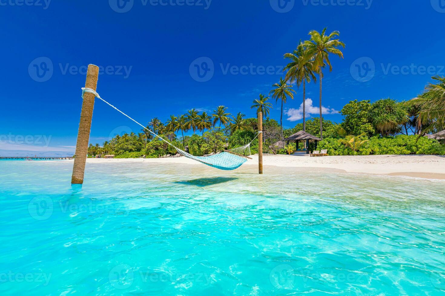 Tropical beach background as summer landscape with beach swing or hammock and white sand and calm sea for beach banner. Perfect beach scene vacation and summer holiday concept. Nature landscape photo