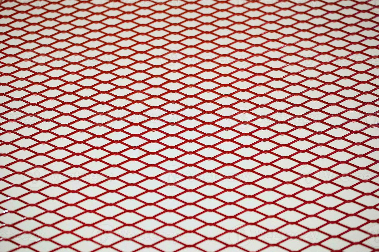 Red chrome Steel Grating seamless structure with soft focus. Steel grate on white background in perspective with Selective focus, mesh, wallpaper, cage, pattern, cell, chain link, isolated. photo