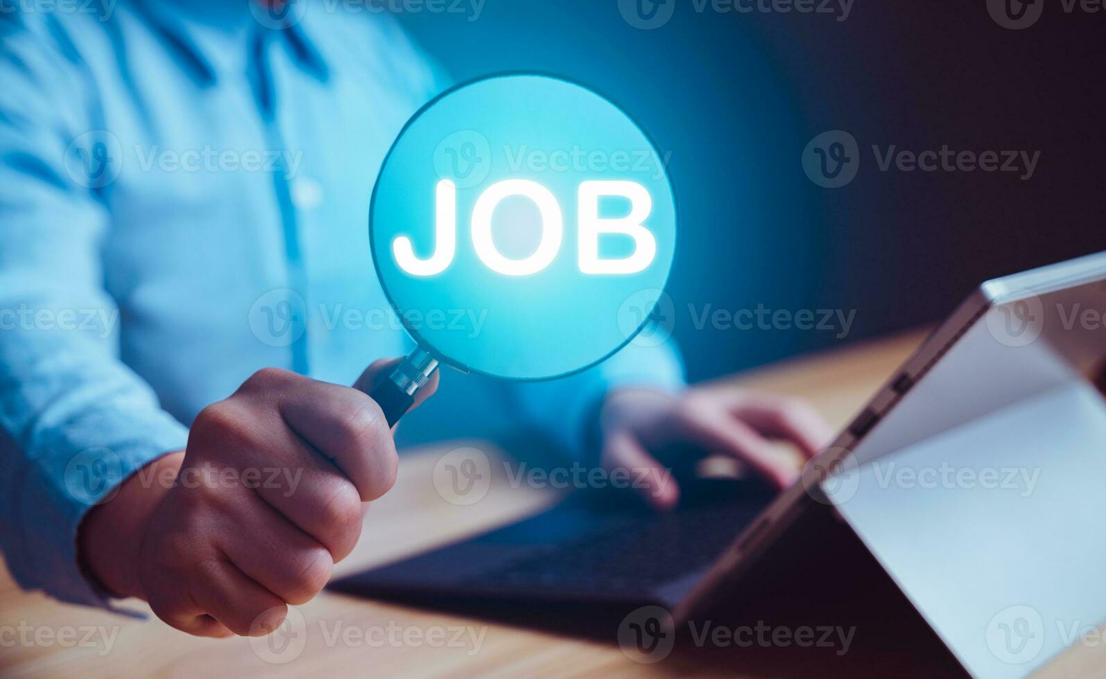Businessman holding magnifier to search and browsing work opportunities online job search computer app. HR job, internet technology, searching information, find your career and recruitment concept. photo