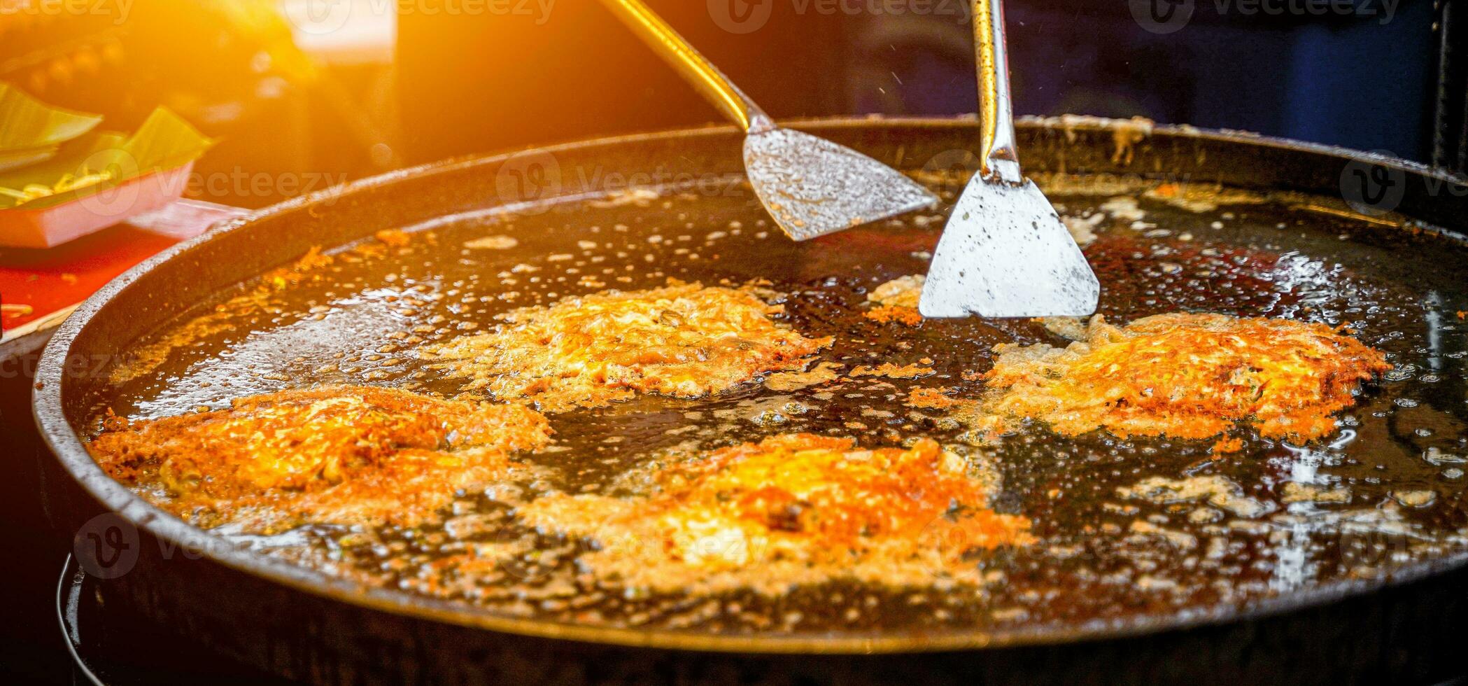 tailandés crujiente frito mejillón panqueques cocido en un caliente cacerola, un famoso calle comida en tailandia el nombre es hoi tod, tailandés comida a noche. foto