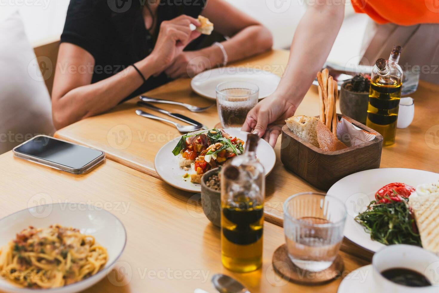 Waitress serving bruschetta appetizer topped with tomatoes wild rocket leaves. photo