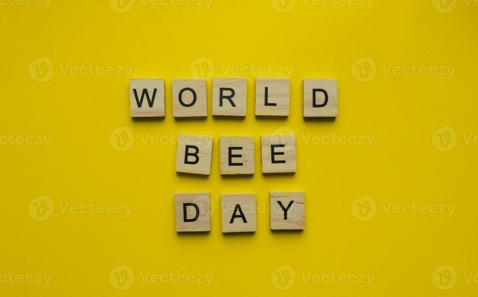 August 19, National Honey Bee Day, World Bee Day, minimalistic banner with the inscription in wooden letters on an orange background photo