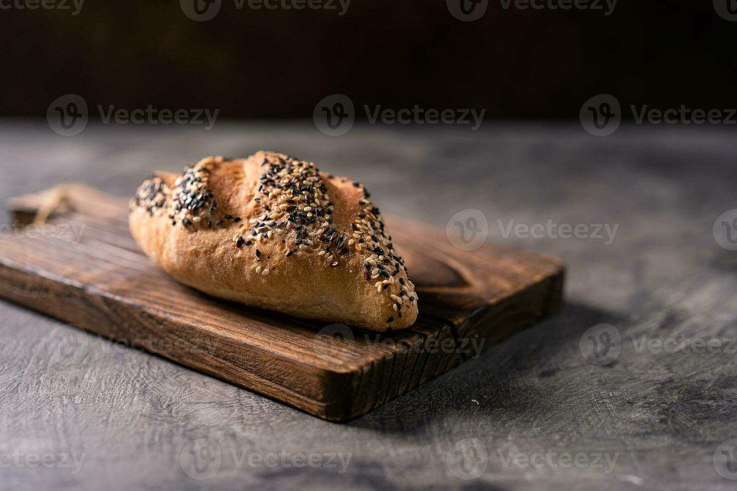 Fresh homemade bread whole wheat baguette on napkin and abstract table. Sourdough bread photo