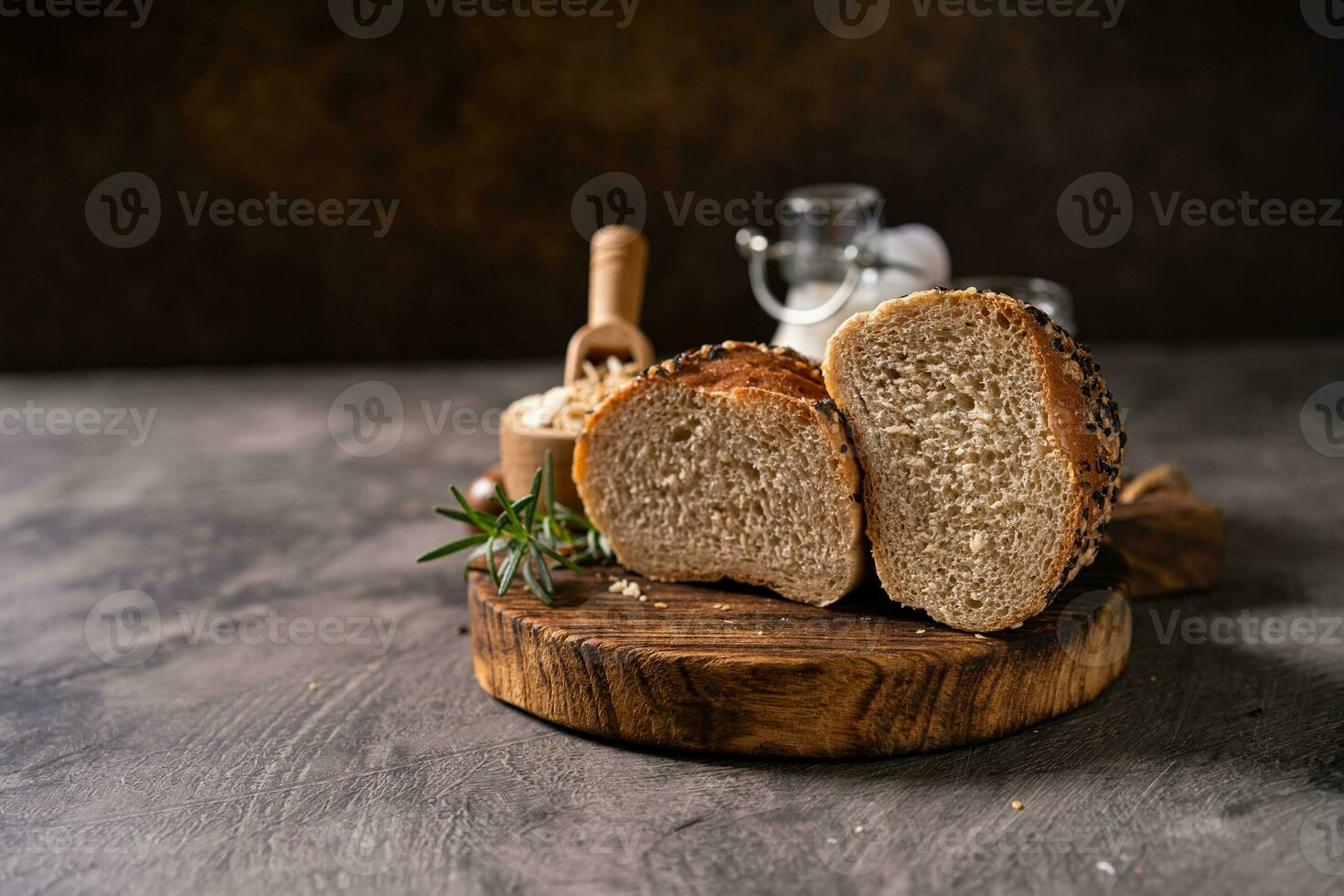 Artisan bread whole wheat baguette white milk and honey on rustic wooden board and abstract table. Sourdough bread photo