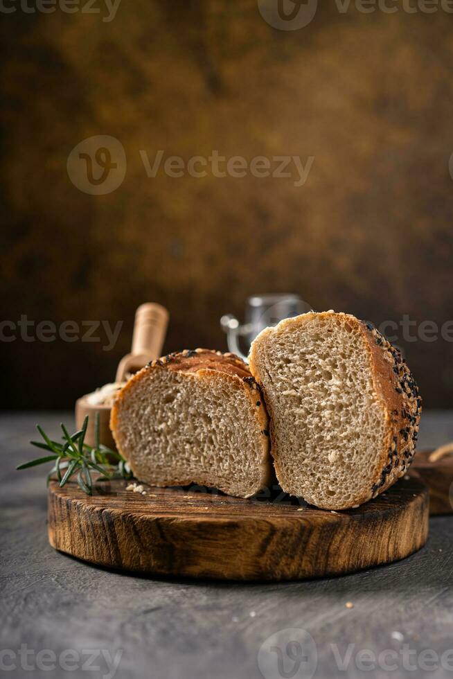Artisan bread whole wheat baguette white milk and honey on rustic wooden board and abstract table. Sourdough bread photo