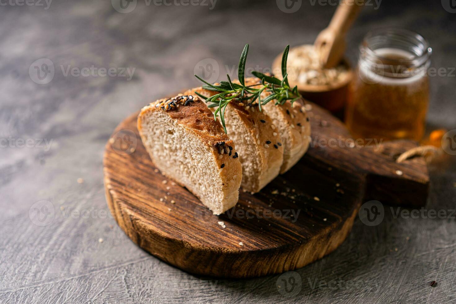 Artisan bread whole wheat baguette white milk and honey on rustic wooden board and abstract table. Sourdough bread photo