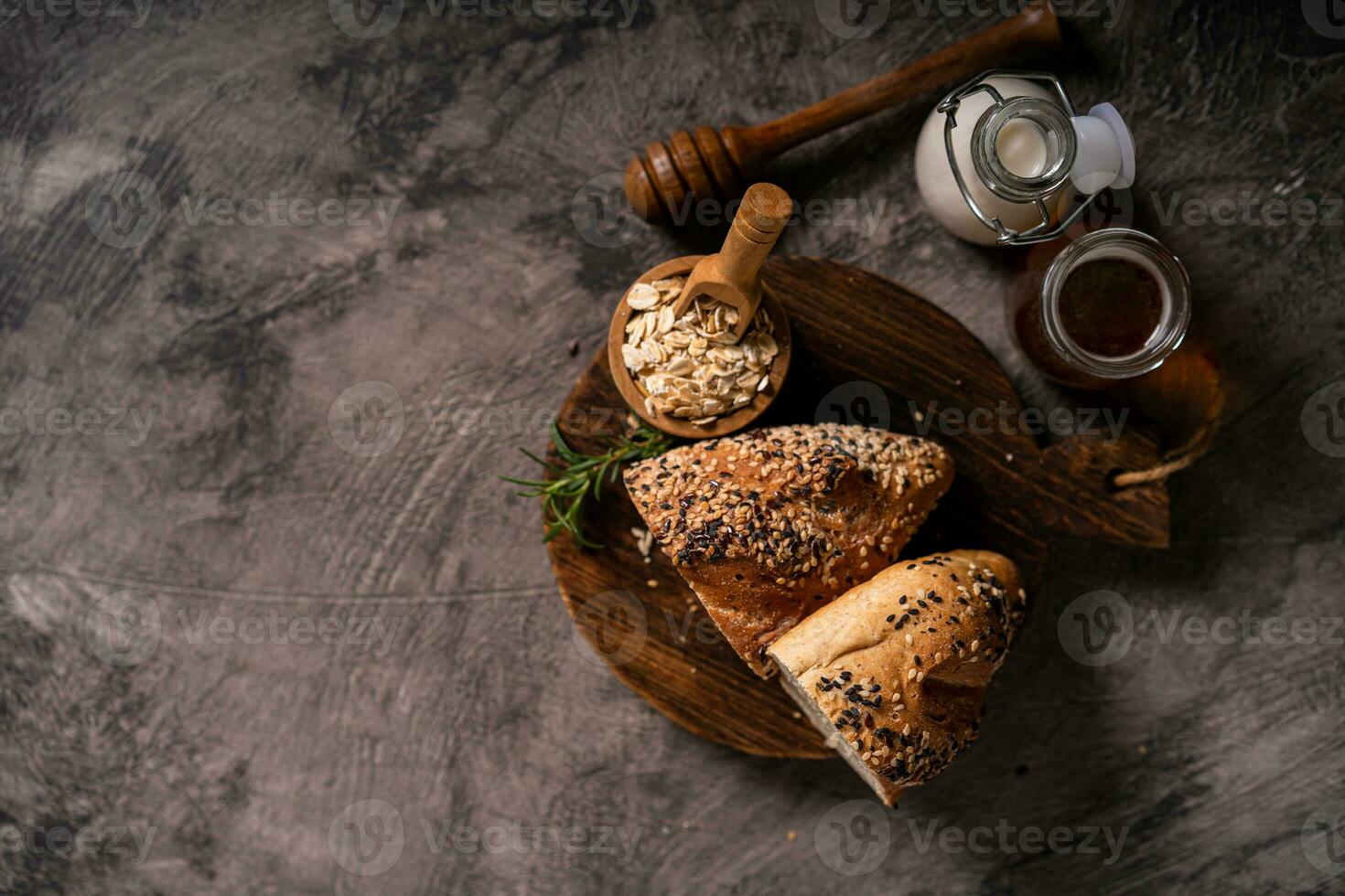 Artisan bread whole wheat baguette white milk and honey on rustic wooden board and abstract table. Sourdough bread photo