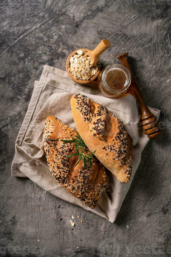 Fresh homemade bread whole wheat baguette on napkin and abstract table. Sourdough bread photo