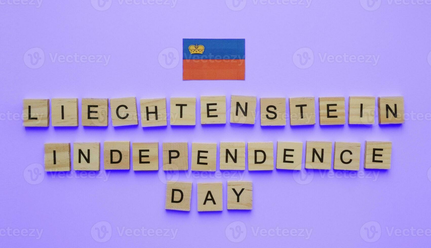 August 15, Liechtenstein independence Day, Liechtenstein national Day, Liechtenstein flag, minimalistic banner with the inscription in wooden letters on a blue background photo