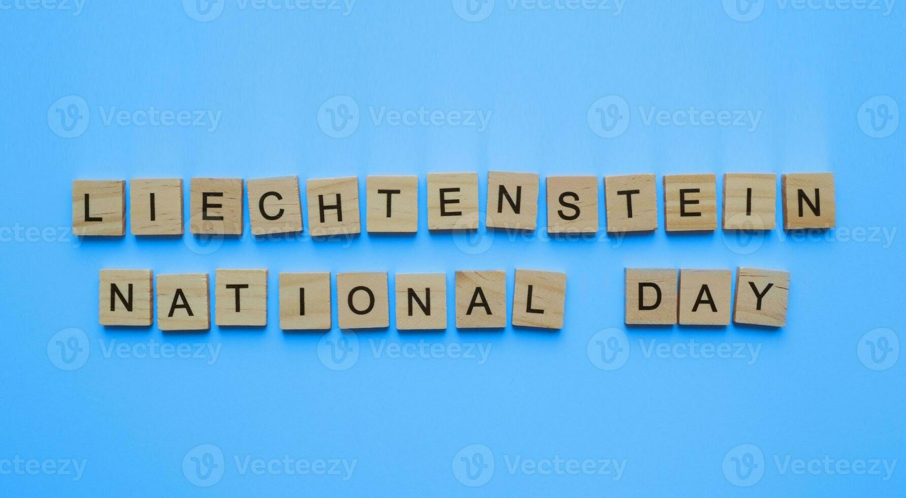 August 15, Liechtenstein independence Day, Liechtenstein national Day, minimalistic banner with the inscription in wooden letters on a blue background photo