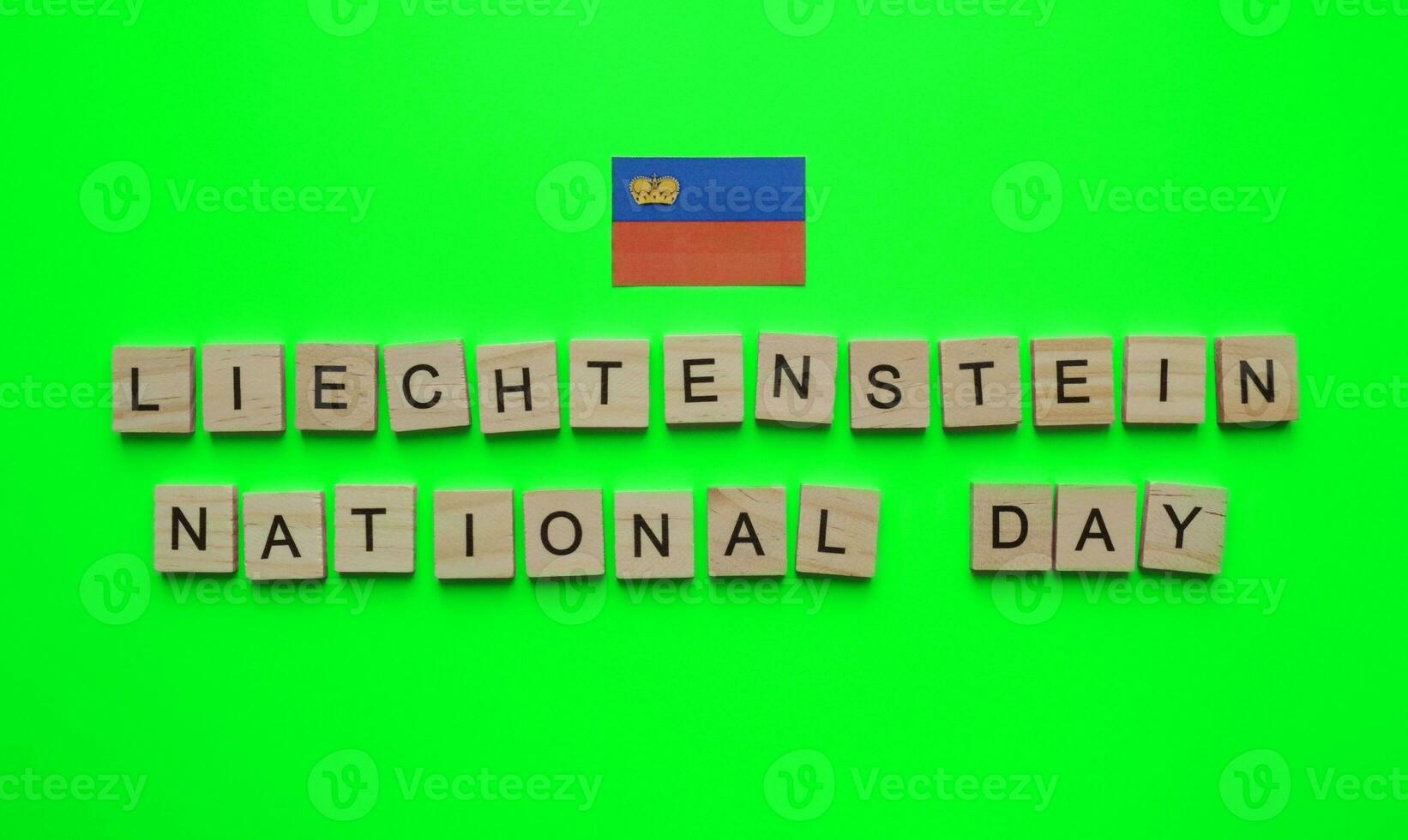 August 15, Liechtenstein independence Day, Liechtenstein national Day, Liechtenstein flag, minimalistic banner with the inscription in wooden letters on a green background photo