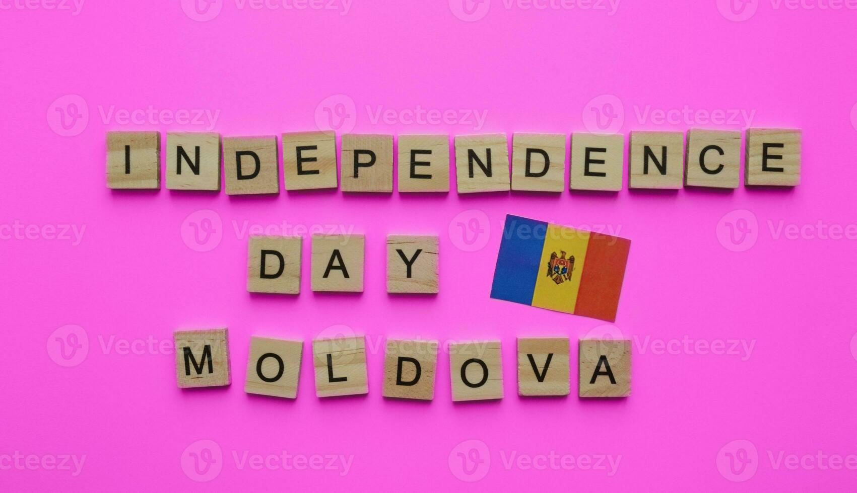 August 27, Moldova Independence Day, flag of Moldova, minimalistic banner with the inscription in wooden letters on a pink background photo