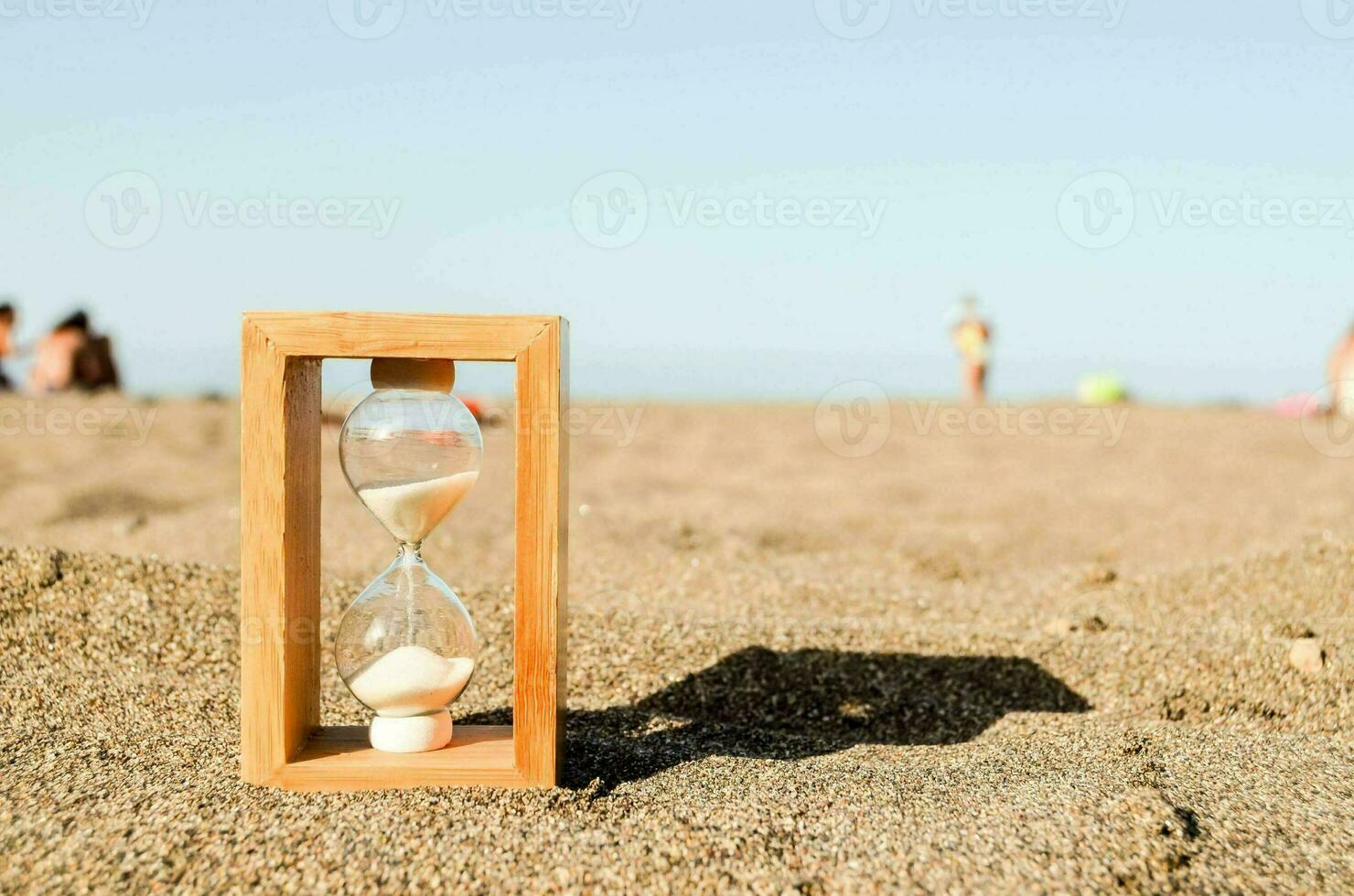 an hourglass on the beach with people in the background photo