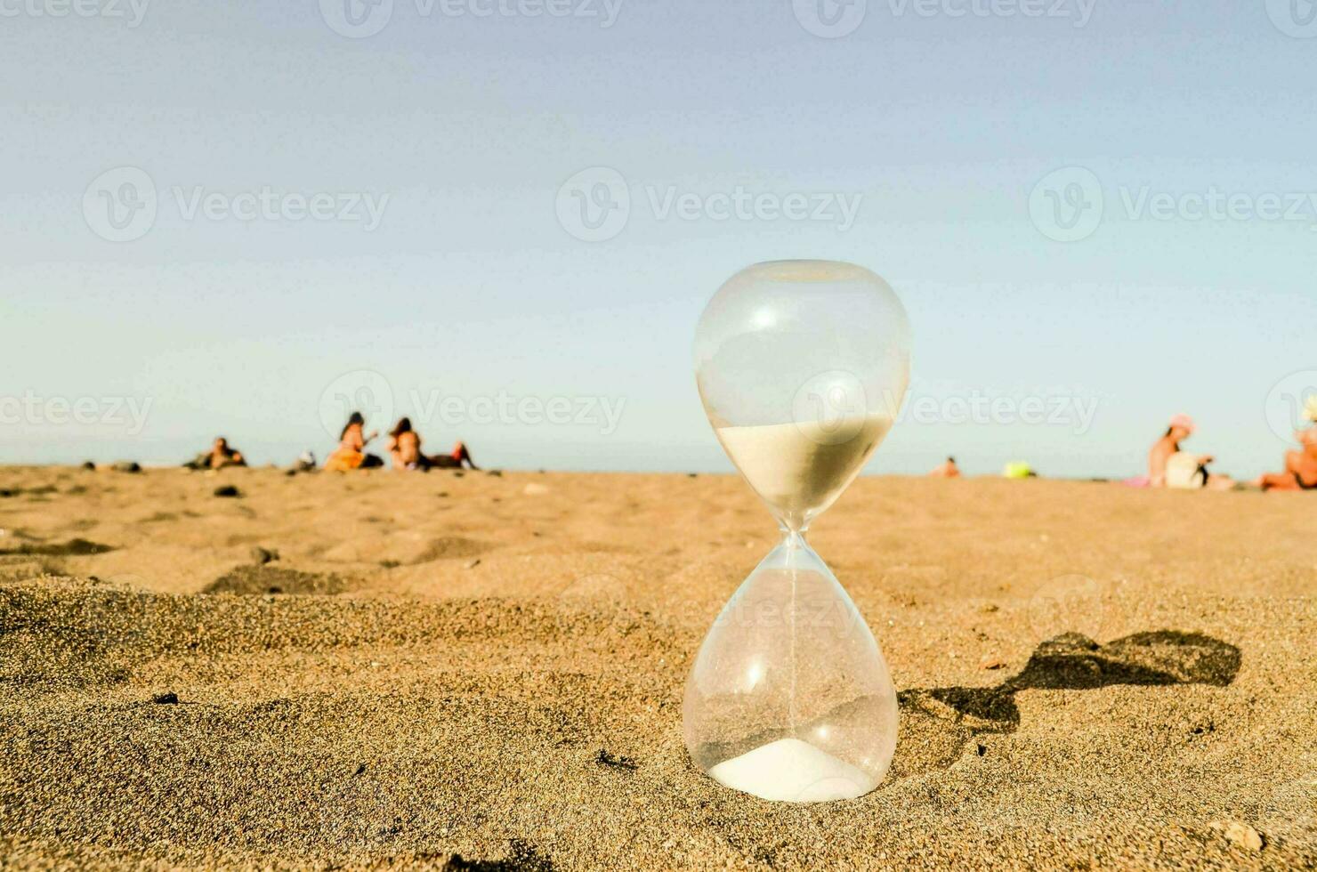 an hourglass on the beach with people in the background photo