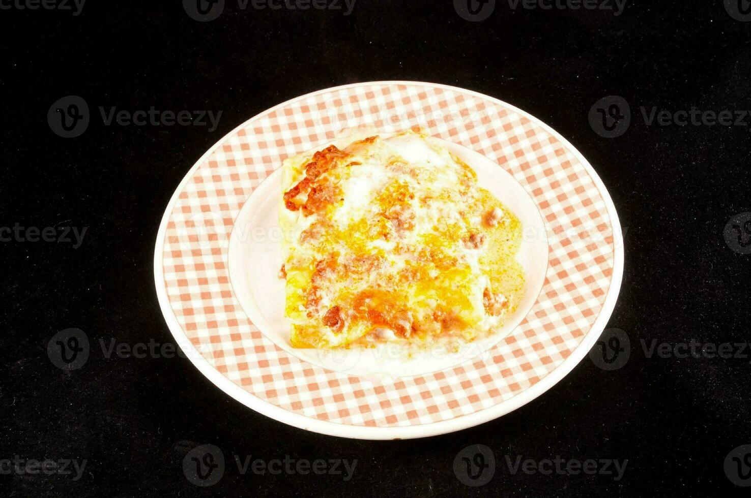 a piece of pizza on a plate with a checkered pattern photo