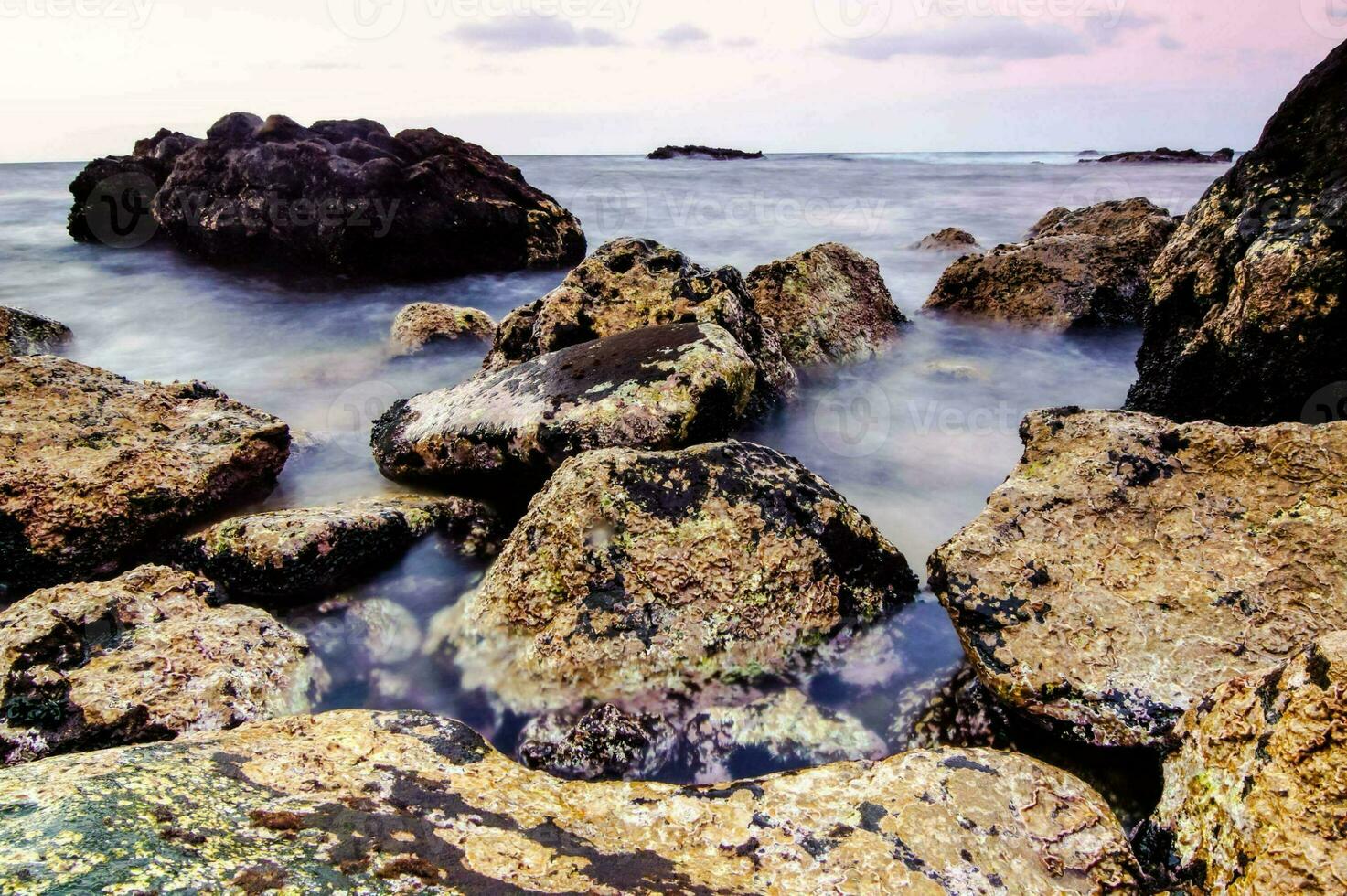 rocks and water at sunset on the beach photo