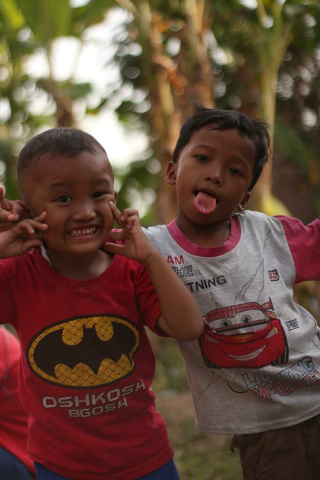 Magelang, Indonesia - August 6, 2023-Portrait of children playing. in the field. expression of pleasure without the burden of life. photo